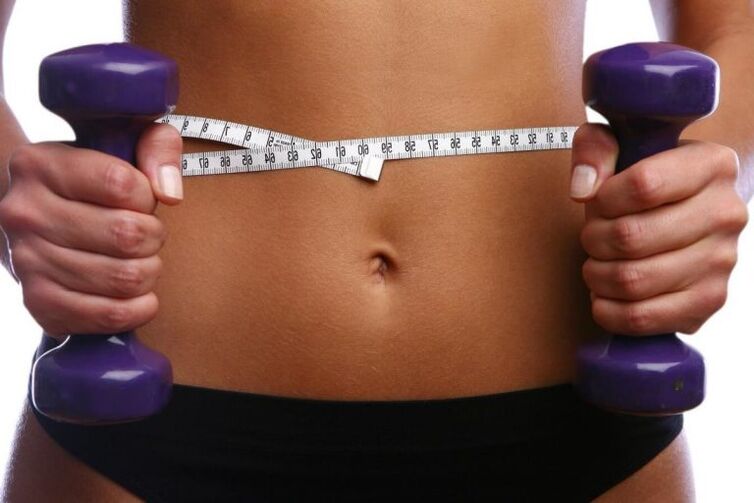 Fitness dumbbells in the hands of a good girl